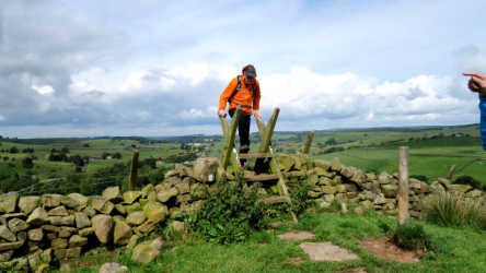 climbing over a stile along the Hadrian's Wall walking route