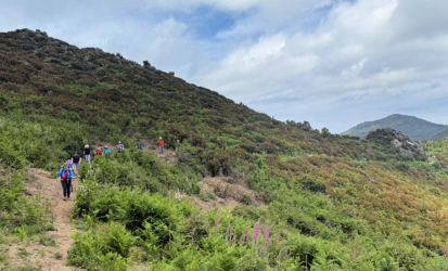 Group hiking along a mountainside along the Mare a Mare Nord, Corsica